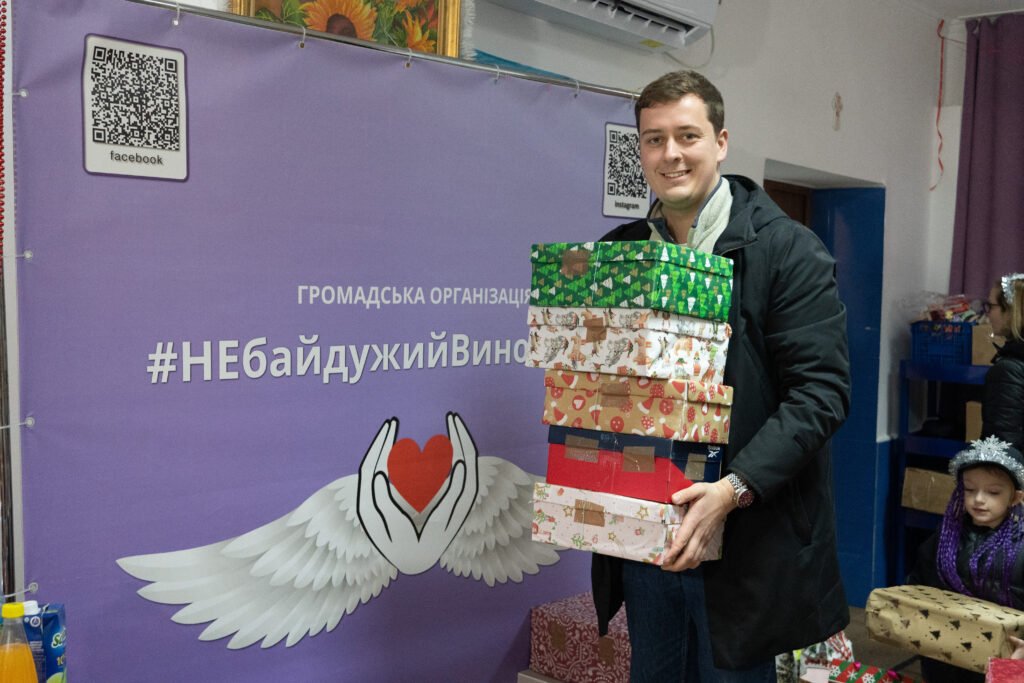 Ein Teammitglied bringt einen Stapel Geschenkkartons zur Verteilung beim Partnerverein Nebaiduzhyi Vynohradiv